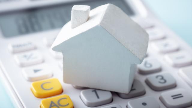a%20small%20home%20figurine%20on%20top%20of%20a%20calculator